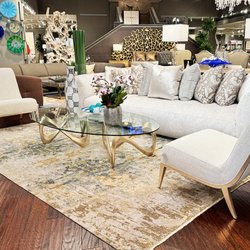 Noel Furniture - Lavish living room featuring a deep plush sofa, elegant accent chairs, and a glass-top coffee table with a luxurious handmade rug.