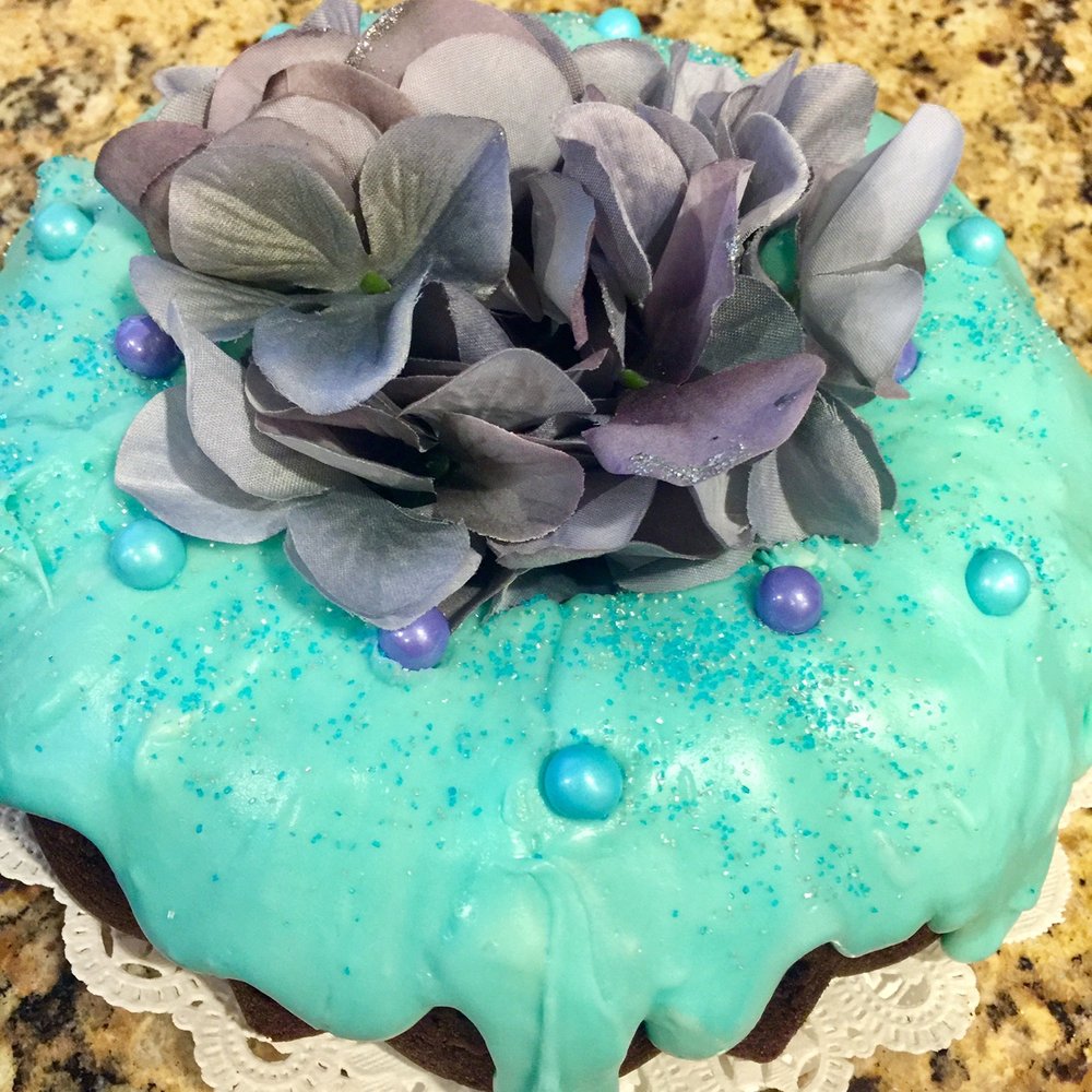Frosting on Top - a cake with blue icing and purple flowers - Cupcakes Near Me Frosting on Top - a cake with blue icing and purple flowers - Cupcakes Near Me