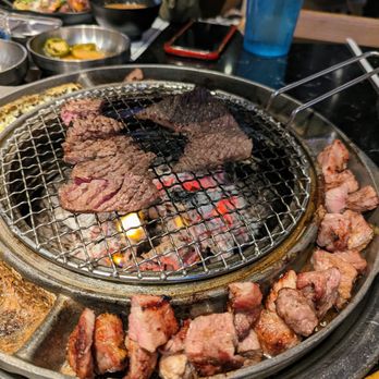 Cow Wow Korean BBQ - Marinated Short Rib on the grill. Pork Neck cooking (being finished) on the edge of the grill. - Korean Near Me - Suwanee, Georgia Cow Wow Korean BBQ - Marinated Short Rib on the grill. Pork Neck cooking (being finished) on the edge of the grill. - Korean Near Me - Suwanee, Georgia
