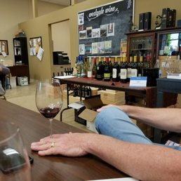 a man sitting at a bar with a glass of wine a man sitting at a bar with a glass of wine