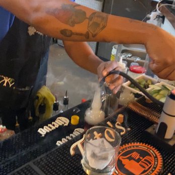 Hollow Spirits Distillery - Ian filling the bottle with smoke, on top of the Old Fashioned creation inside the bottle - Beer, Wine & Spirits Near Me - Albuquerque, New Mexico