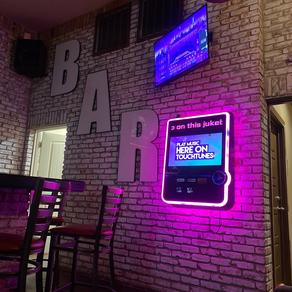 a neon sign on a brick wall a neon sign on a brick wall
