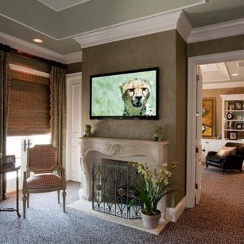 HomeSmart Central - Custom Installation.  TV Mounted on wall above fireplace with Articulating Arm.  Equipment concealed behind TV. - Home Theatre Installation Near Me - Sarasota, Florida