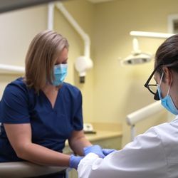 Coastal Connecticut Dentistry - Dr. Dibner and her assistant helping a patient