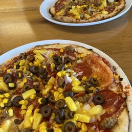 two pizzas on a table two pizzas on a table