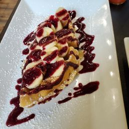 Half waffle with banana, blueberry and a blueberry sauce
