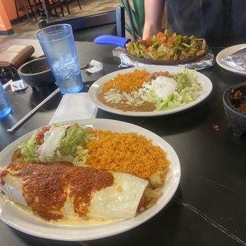 El Jimador - a woman sitting at a table with plates of mexican food - Mexican Near Me - Sussex, Wisconsin El Jimador - a woman sitting at a table with plates of mexican food - Mexican Near Me - Sussex, Wisconsin