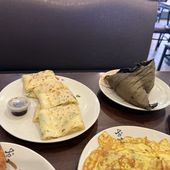 Yung Ho Cafe - 7. Bamboo Leaf Wrapped Sticky Rice 香菇肉粽 (right) Egg pancake roll (left) - Taiwanese Near Me - San Gabriel, California Yung Ho Cafe - 7. Bamboo Leaf Wrapped Sticky Rice 香菇肉粽 (right) Egg pancake roll (left) - Taiwanese Near Me - San Gabriel, California