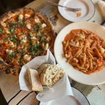 Da Vinci - a plate of pasta and a pizza on a table - Pizza Near Me - Bloomington, Indiana Da Vinci - a plate of pasta and a pizza on a table - Pizza Near Me - Bloomington, Indiana