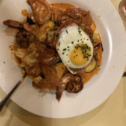 Shrimp and grits with bacon, cheese and a fried egg Shrimp and grits with bacon, cheese and a fried egg