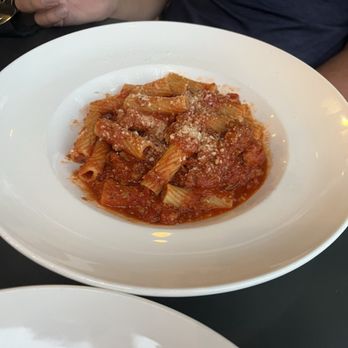 Bar La Tosca - Rigatoni - A white bowl contains rigatoni pasta with tomato sauce and grated cheese, served at a restaurant. - Italian Near Me - Ames, Iowa