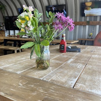 Cleats Bar & Grille - Tables under covering with fresh flowers - Sports Bars Near Me - Lansing, Michigan Cleats Bar & Grille - Tables under covering with fresh flowers - Sports Bars Near Me - Lansing, Michigan