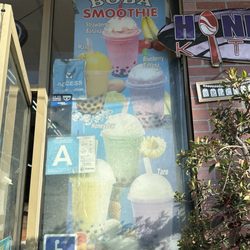 Honeybee Donuts - Boba menu on the window.  Strawberry-Banana, mango, blueberry-banana, honeydew & taro.