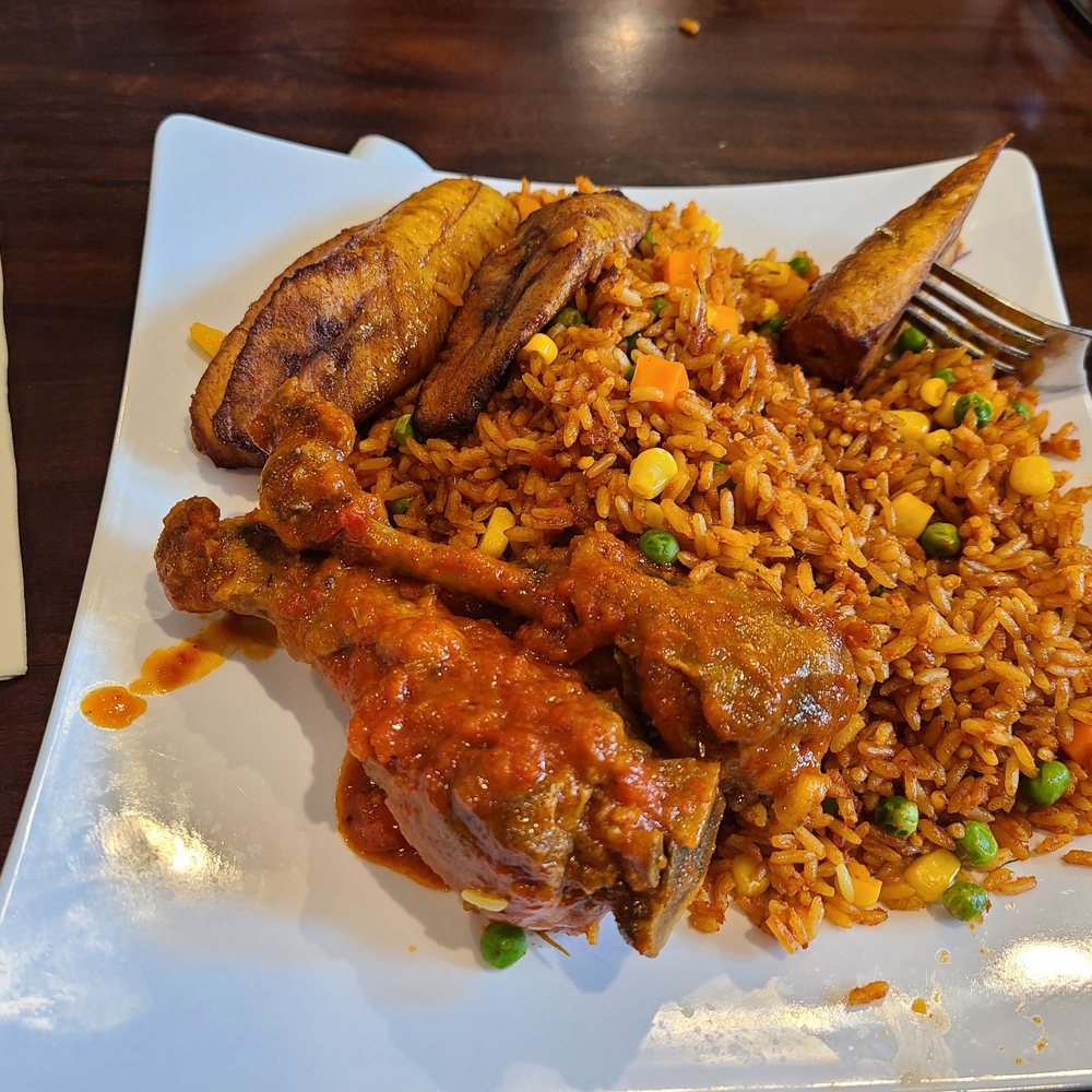 Trices Cafe and Lounge - Jollof rice with chicken. Eating a plantain. Jollof Rice Jollof Rice - African Near Me - San Antonio, Texas Trices Cafe and Lounge - Jollof rice with chicken. Eating a plantain. Jollof Rice Jollof Rice - African Near Me - San Antonio, Texas