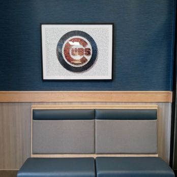 Culver's - A seating area features a blue bench with a padded backrest against a blue wall, with a framed logo above. - Fast Food Near Me - Chicago, Illinois