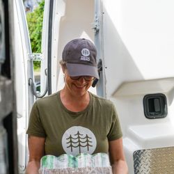 Community Cupboard Mend - Employee Sara Evans helping unload canned goods from the MEND van for the Community Cupboard.