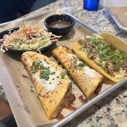 Birria, pollo & carnitas tacos with a side of slaw.