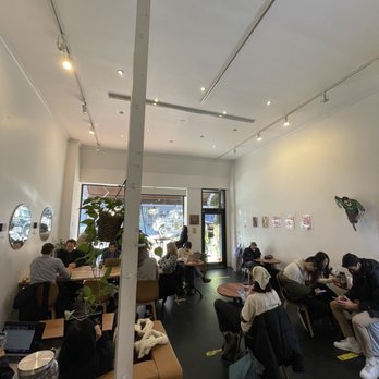 About Coffee - people sitting at tables in a coffee shop - Coffee & Tea Near Me - New York, New York About Coffee - people sitting at tables in a coffee shop - Coffee & Tea Near Me - New York, New York