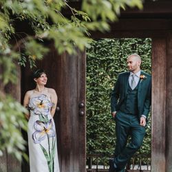 Angela Gaspar Photography - A bride wearing a floral dress and groom in an emerald green suit at their wedding at Shofuso Japanese Garden in Philadelphia