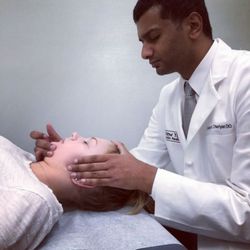 New York Osteopathic Medicine - Dr. Cheriyan performing jaw and cranial manipulation.