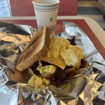 Greg's Breakfast Bar - Bacon sandwich and cup of coffee. The picture captures the steam coming off the coffee. - Breakfast & Brunch Near Me - Montgomery, Alabama Greg's Breakfast Bar - Bacon sandwich and cup of coffee. The picture captures the steam coming off the coffee. - Breakfast & Brunch Near Me - Montgomery, Alabama