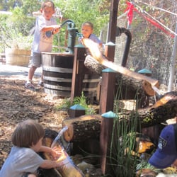 Happy kiddos pumping water down the log sluiceway in the "rnature experience" area of the Grace playground.