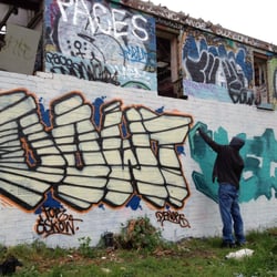 Orchard Sports Centre - A graffiti artist at work on the main wall at the ruined Orchard sports centre ( Anerley )