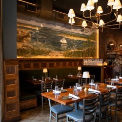 Forgotten Tonic - Warm lighting, cozy banquettes, and a coastal mural set the scene for dinner and cocktails at Forgotten Tonic.