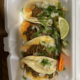three tacos in a styrofoam container three tacos in a styrofoam container