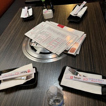 Takumi Restaurant - a table with a menu and a water bottle - Sushi Bars Near Me - Albuquerque, New Mexico