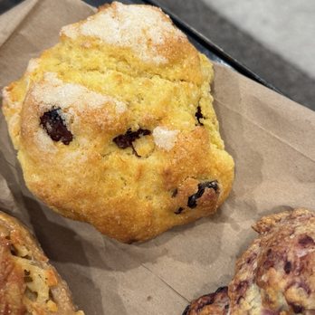 The Cheeseboard Collective - A golden-brown muffin with chocolate chips on a brown paper liner, likely from a bakery or cafe. - Bakeries Near Me - Berkeley, California