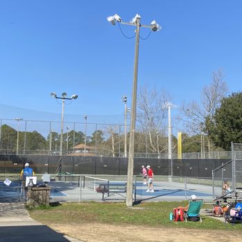 Treaty Park - Tennis courts, marked off for large pickleball tournament - Tennis courts are set up for a pickleball tournament, with players on the courts and spectators nearby, surrounded by fencing and outdoor lighting. - Parks Near Me - St. Augustine, Florida