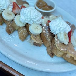 Rick's Cafe - Fruity French Toast: Topped with powdered sugar, bananas, strawberries, and whipped cream. Apple compote on the side.