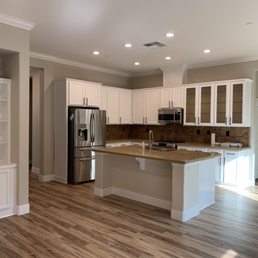 a kitchen with white cabinets and wood floors a kitchen with white cabinets and wood floors