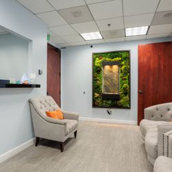 Relax in our calming lobby featuring plush seating, natural décor, and a tranquil water wall while you wait for your wellness care.