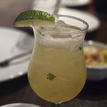 Benihana - Exotic mojito, pretty good but took forever to get it - A pale yellow cocktail with ice in a curvy glass, garnished with a lime wedge, on a restaurant table. - Sushi Bars Near Me - Concord, California