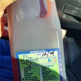 a hand holding a gallon of liquid a hand holding a gallon of liquid
