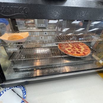 Silver Express - two pizzas cooking in the oven - A glass display case contains a slice of cheese pizza on a tray and a small dish, likely in a convenience store or deli. - Convenience Stores Near Me - Indianapolis, Indiana