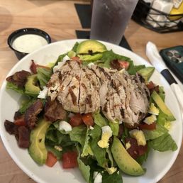 Cobb Salad: $15.00 Romaine, grilled chicken, tomato, avocado, bacon, egg, blue cheese crumbles. Served with house ranch.