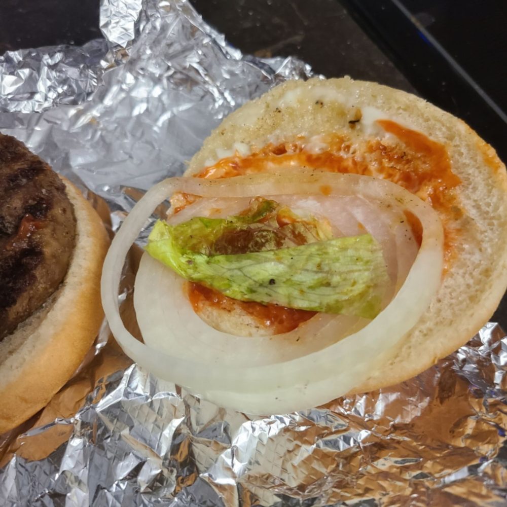 a hamburger and onion on tin foil a hamburger and onion on tin foil