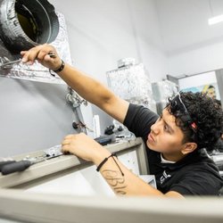 United Education Institute - Stone Mountain - HVAC student working on unit.