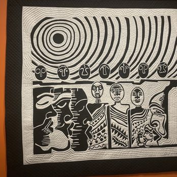 Renwick Gallery - Carolyn Masloomi - A quilted textile art piece features abstract tribal motifs in black and white, with concentric circles, stylized faces, and geometric patterns. - Art Galleries Near Me - Washington, DC, District of Columbia