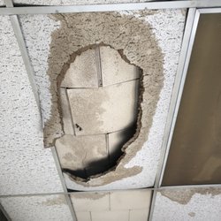 Crown Environmental - Asbestos-containing 1'x1' acoustical ceiling tiles falling due to a pipe leak.