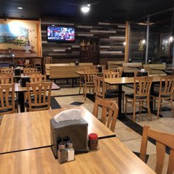 Ops Pizza Kitchen and Cafe - Tables and chairs and a single TV.