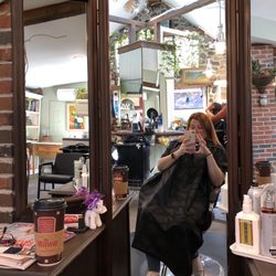 Marty's Salon - Marty's Salon through the antique looking stylist station mirror