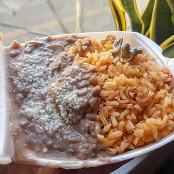 Dahlia - a hand holding a container of rice and beans - Mexican Near Me - Brooklyn, New York