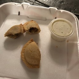 a half eaten pastry and a cup of sauce a half eaten pastry and a cup of sauce