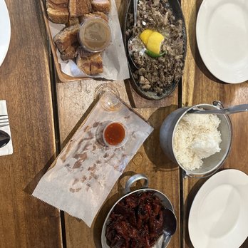 Isla Restaurant - Isla Table with food: Fried Liempo, Tocino, Sisig with Egg, Steam Rice, and Lumpiang shanghai - Filipino Near Me - San Bruno, California