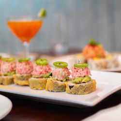 Spicy Tuna Bomb: Crispy spicy tuna roll, topped with spicy tuna, avocado, jalapeño, and sriracha.