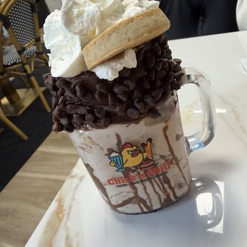 Chick'n Chill - A chocolate milkshake in a glass mug with whipped cream, chocolate chips, and a cookie on top, served at Chick'n Chill in Rutherford, NJ. - Desserts Near Me - Rutherford, New Jersey